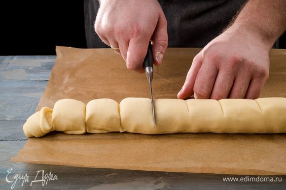 Затем скатайте тесто с начинкой в рулет и разрежьте на ровные части 3 см шириной. Дайте постоять 15–20 минут.