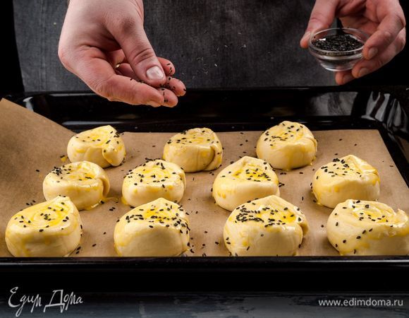 Смажьте булочки желтком, посыпьте кунжутом. Выпекайте 30 минут при 190°С, пока не зарумянятся. 