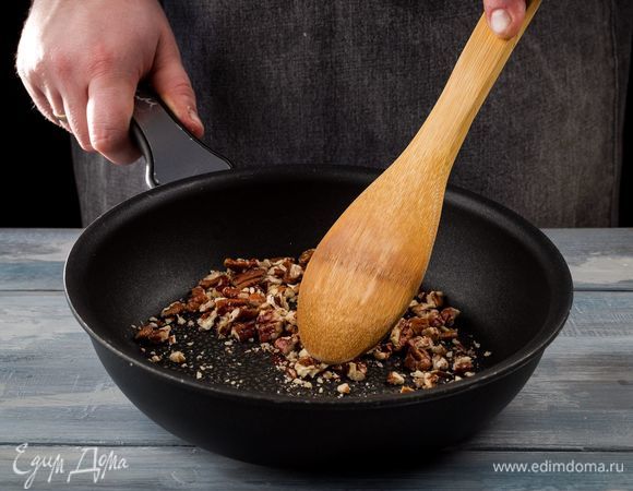 Промойте и высушите изюм. Обжарьте измельченные орехи.