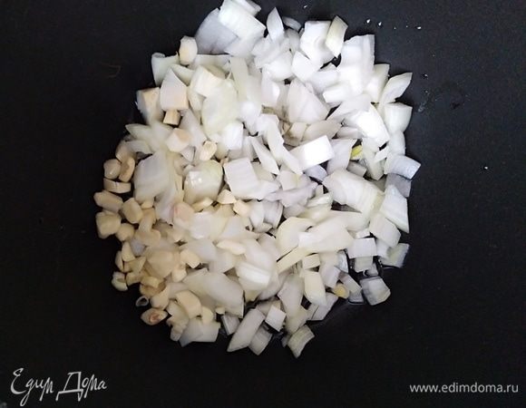 Разогреть растительное масло. Лук (большую головку) нарезать кубиками и  обжарить на среднем огне в течении 5 минут. Добавить мелко нарезанный чеснок. 