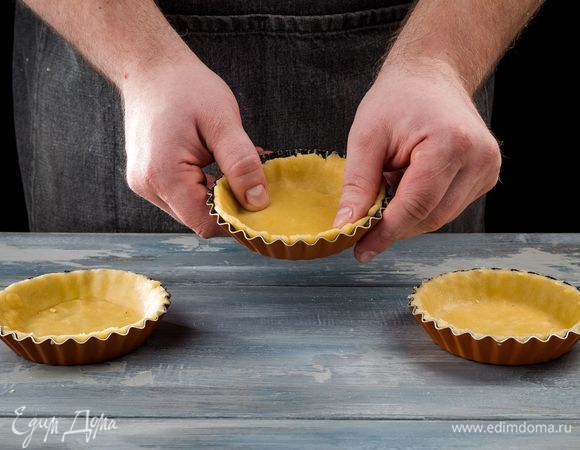 Формочки для тарталеток смажьте растительным маслом. Достаньте тесто из холодильника и выложите в формочки, плотно прижимая к стенкам. Выпекайте корзиночки при 200°С 20 минут до золотистого цвета.