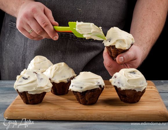 Готовые кексы остудите, украсьте воздушным кремом и апельсиновой цедрой.