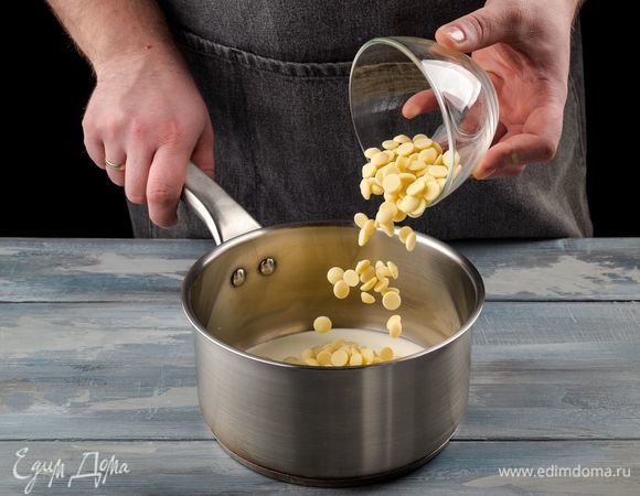 Оставшиеся 50 мл сливок нагрейте в сотейнике и растопите в них белый шоколад.