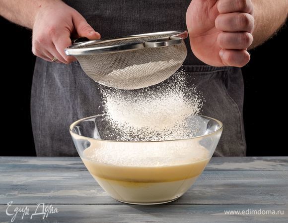 В большой емкости взбейте яйца до увеличения объема в 2 раза. Постепенно добавьте 250 г сахарной пудры. Взбивайте еще 10 минут. Соедините творожную и яичную массы, смешайте с помощью миксера. Добавьте лимонную цедру, и снова все перемешайте. Просеивая муку с разрыхлителем, в 3 приема введите ее в основную массу и слегка взбейте миксером.