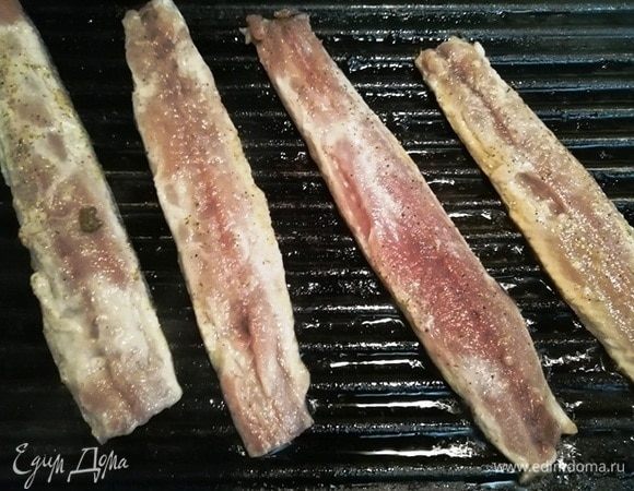 Выкладываем сайру кожей вниз на раскаленную сковороду гриль, смазанную оливковым маслом, и жарим рыбу 1 минуту.