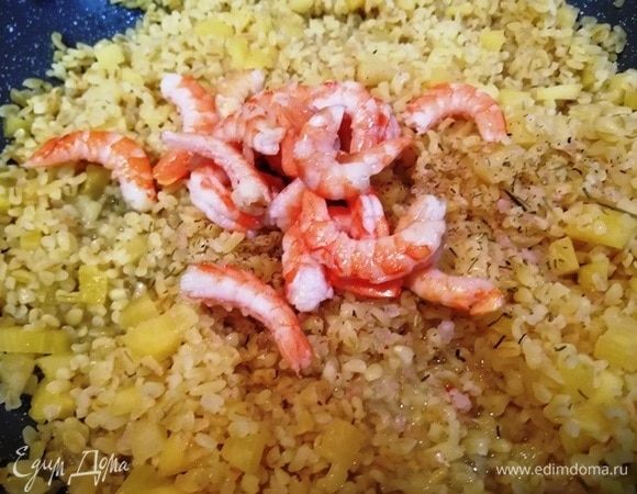 Добавляем креветки к булгуру, выключаем огонь, перемешиваем и оставляем на 5 минут под крышкой.