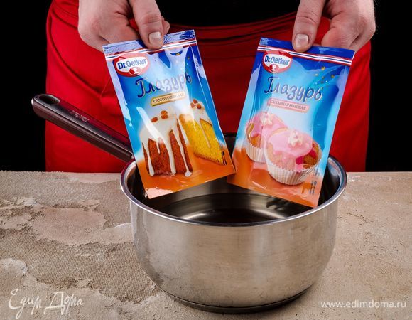 Достаньте печенье из духовки и остудите. Приготовьте сахарную белую и розовую глазурь Dr. Oetker. Опустите пакетики с глазурью в горячую воду на 3–5 минут. Выложите их на полотенце и слегка надавите на них. чтобы сделать текстуру глазури более однородной.