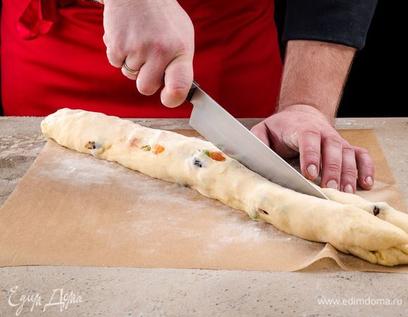 Еще немного обомните тесто и сделайте из него рулет. Затем разрежьте его вдоль на две части.