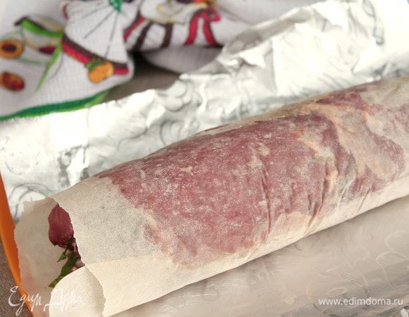Свернуть рулет. Завернуть его в слой бумаги для выпечки, хорошенько уплотняя и натягивая бумагу, но в то же время аккуратно, чтобы не порвать ее.