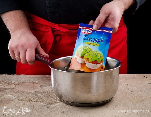 Приготовьте глазурь Dr. Oetker. Опустите пакетик с глазурью в горячую воду на 3–5 минут. Выложите его на полотенце и слегка надавите, чтобы сделать текстуру более однородной.