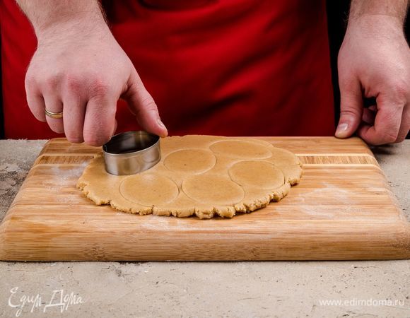 Раскатайте тесто на промасленной бумаге для выпечки и вырежьте пряники при помощи формочек или трафаретов.