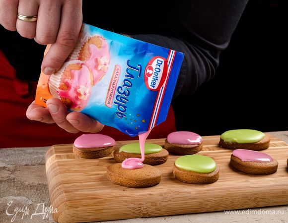 Срежьте уголки и украсьте половину пряников зеленой глазурью, а вторую половину — розовой.