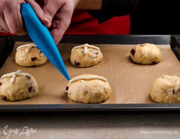 Нарисуйте на булочках кресты кондитерским мешком. Выпекайте булочки 30 минут при температуре 200°С.