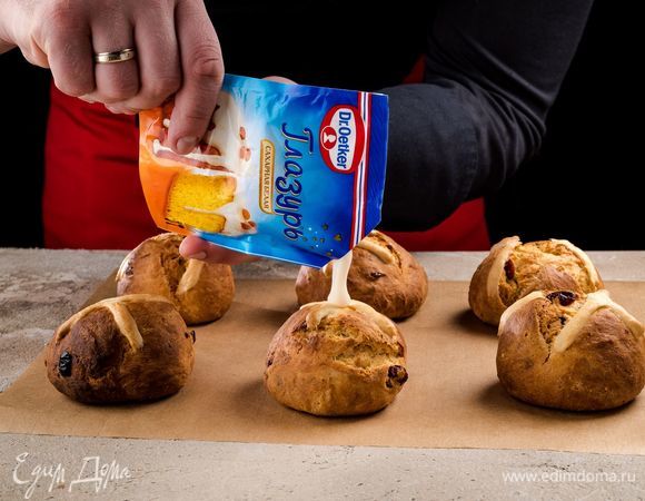 Срежьте уголок пакетика и украсьте глазурью остывшие булочки.