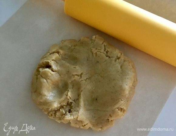 По истечении 30 мин охлажденный комочек теста достать, размять немного пальчиками и раскатать между двумя листами пекарской бумаги толщиной 0,3 см. Перенести в разъемную форму, сформировать небольшие бортики, наколоть часто вилочкой и отправить на час в морозильную камеру.