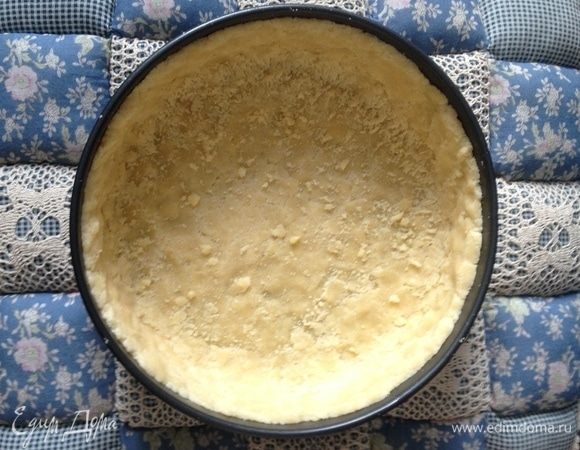 Песочную крошку выложить в форму (диаметр 26 см), две горсти крошки отложите для посыпки. Утрамбуйте руками по форме с бортиками.