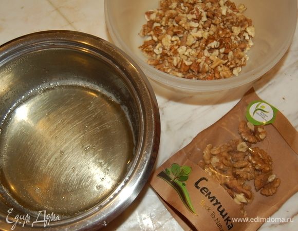 Для хрустящих орешков следует вначале сварить сироп. Смешать воду, сахар и мед. Довести до кипения и вылить на поломанные орешки. Перемешать и выложить на противень. Готовить до золотистого цвета около 15 минут на 140°С.