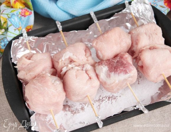 Формочку, на которую свободно можно уложить шпажки и в которой шарики не будут касаться дна, застелить фольгой. Насыпать на дно тонкий слой соли. Это для того, чтобы не пришлось потом от пригоревшего сока отмывать форму, а благодаря соли выделившийся сок будет гореть не так активно. При наличии, можно приготовить на гриле, а можно, как я, в предварительно разогретой духовке до 190°С 30 минут с одной стороны и 30 минут с другой.