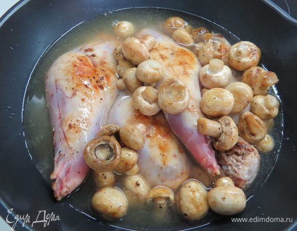 Влить куриный бульон в сковороду с кроликом и грибами.