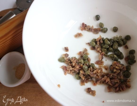 В миске смешать каперсы, лимонный сок, оливковое масло, анчоусы.