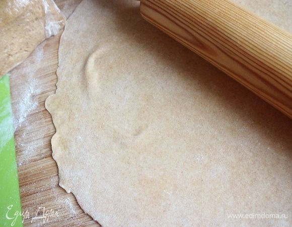 Раскатать кусочек теста максимально тонко на присыпанной пшеничной  мукой поверхности, раскатывать нужно от центра к краям. Оставшееся тесто обязательно завернуть в пленку, так как оно быстро сохнет.