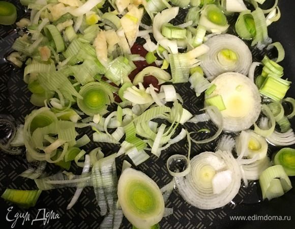 Поставить воду для макарон на огонь, присолить. Когда вода закипит, всыпать к ней макароны. Варить половину времени, указанного на упаковке. А пока займемся начинкой. Лук-порей (1 шт.) порезать колечками. Пару зубчиков чеснока почистить, раздавить тыльной стороной ножа и мелко порубить. В сковороде разогреть растительное масло и начать обжаривать лук с чесноком.