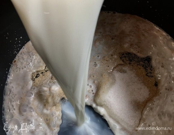 Влить теплое молоко и тщательно размешать ложкой. Накрыть миску кухонным полотенцем и поставить в теплое место минут на 10. Дрожжи должны «заработать», и появиться пена.