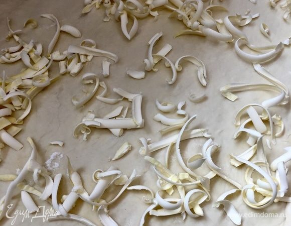 Мысленно поделить тесто пополам и на одну половину натереть на терке холодное сливочное масло.