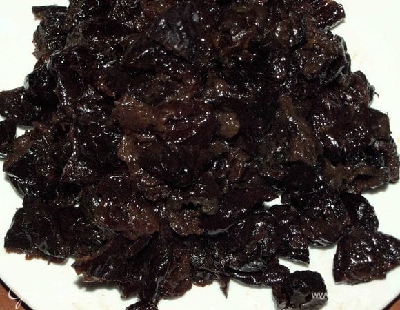 Чернослив отжать от коньяка. Нарезать на 2–3 половинки, если чернослив крупный, то на 4 или 5 частей. 