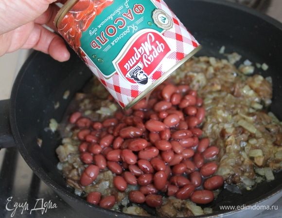 К луку добавьте измельченные отваренные грибы и фасоль ТМ «Фрау Марта». Перемешайте и продолжайте обжаривать все вместе до полного выпаривания жидкости. Немного разомните фасоль, но не до состояния пюре. Вкуснее начинка получится с кусочками фасоли.
Добавьте в начинку по вкусу соль и перец.