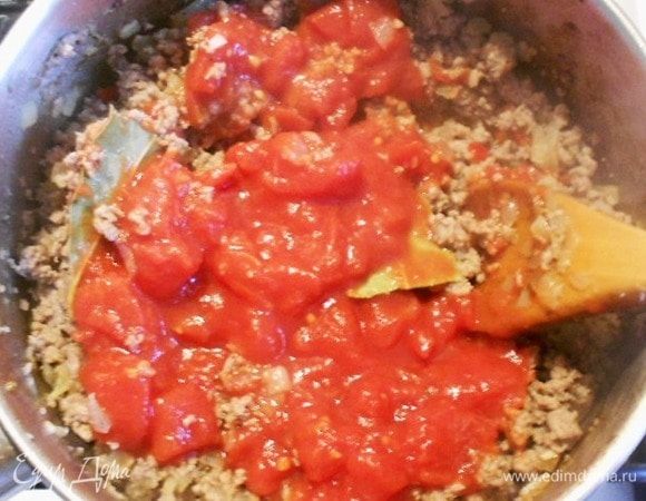 Переложить луковую смесь к мясу, хорошо перемешать, добавить консервированные нарезанные томаты из банки, еще перемешать и готовить 5 мин. 