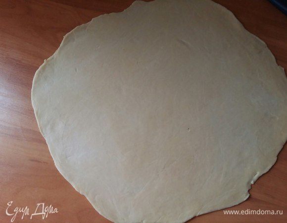 Раскатать одну часть теста в диаметре 30 см. Перенести на силиконовый коврик, на нем будем работать дальше с тестом. Дальше поймете, почему.