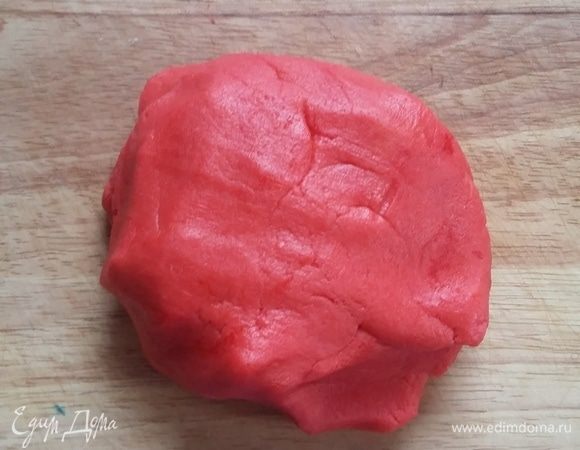 Ввести яйцо с красителем, замесить тесто и скатать его в шар. Раскатать между пергаментом и убрать в холодильник на 2 часа.