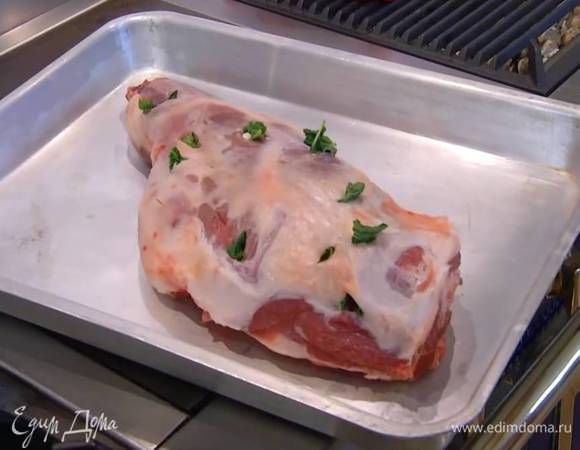 Чеснок почистить, разрезать вдоль на несколько частей, обернуть каждую в лист мяты и вставить в надрез на ягнятине (половину мяты оставить для украшения).