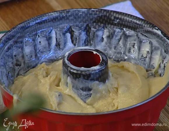 Форму диаметром 22 см с выемкой посередине смазать оставшимся сливочным маслом, выложить на дно миндаль, затем тесто и равномерно распределить его.