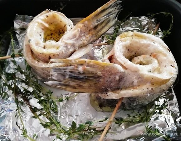 Заверните щуку в рулет, скрепите шпажками. Переложите на противень, сбрызните оливковым маслом и отправьте в духовку, разогретую до 180°С, на 25–30 минут. 