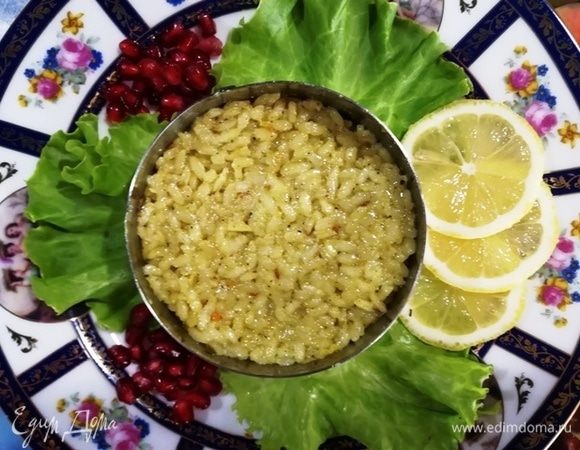 Готовим блюдо к подаче. На листы салата устанавливаем кулинарное кольцо, выкладываем рис. Украшаем дольками лимона и зернами граната (или на свое усмотрение).