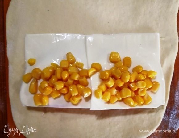 Далее — ломтики сыра и кукуруза. Обернем кукурузу свободными краями сыра.