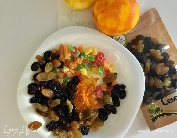 В миске смешать изюм, цукаты, цедру лимона и апельсина.