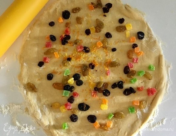 И раскатать тесто в овал толщиной 1–1,5 см. На тесто выложить половину начинки.