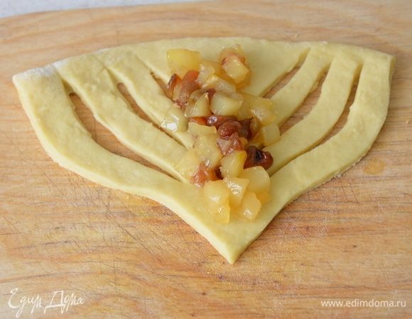 На каждом треугольнике делаем по 3 разреза параллельно каждой из 2-х сторон. В середину выкладываем начинку (1,5 ст. л.). Накрываем начинку сначала с одной стороны, затем с другой.