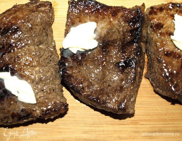 Готовое мясо перекладываем на доску, кладем небольшой кусочек сливочного масла.
