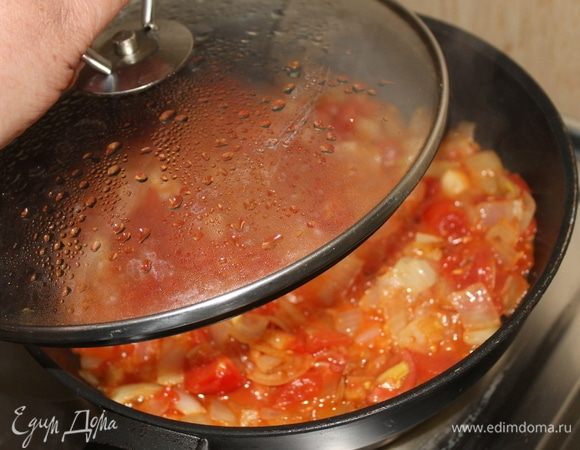 Далее добавьте к луку нарезанные помидоры и тушите овощи под крышкой.