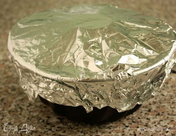 Накрыть форму фольгой. В центре сделать отверстие для равномерной циркуляции горячего воздуха при выпечке. Выпекать 70–75 минут, затем духовку выключить и оставить в ней пирог на 10 минут.