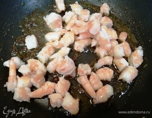 Выкладываем в сковороду креветки и обжариваем 3 минуты.