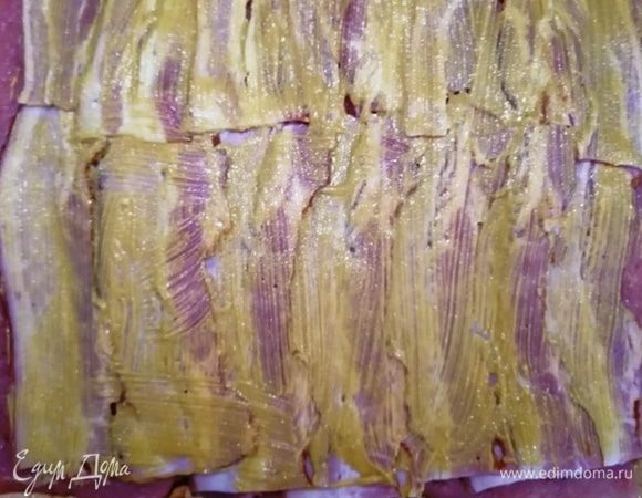 Выкладываем мясо жирной стороной вниз. Выкладываем на свинину бекон, смазываем горчицей.
