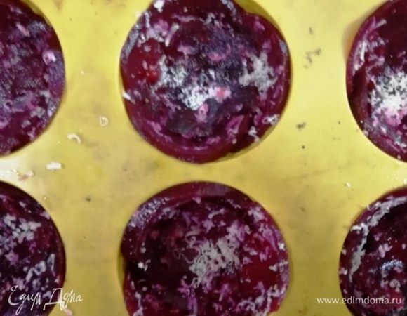 В силиконовые формы выкладываем тонко нарезанную вареную свеклу и посыпаем тертым твердым сыром.  