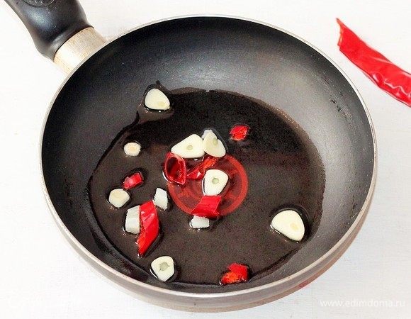 На разогретом растительном масле (2 ст. л.) обжариваем чеснок и острый перец до появления аромата. Затем овощи удаляем, масло оставляем.
