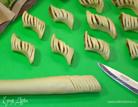 Сверху каждый кусочек надрезать по всей поверхности, затем сжать посередине, а края завернуть в разные стороны, формируя печенье. 