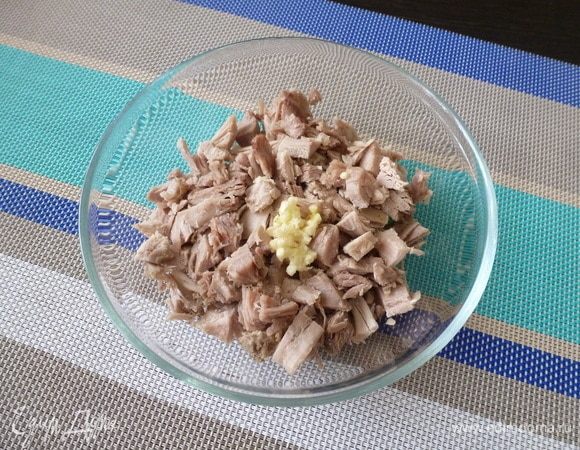 Мясо индейки нарезать на кубики, выдавить чеснок, посолить, поперчить и перемешать. Это основной наполнитель заливного.